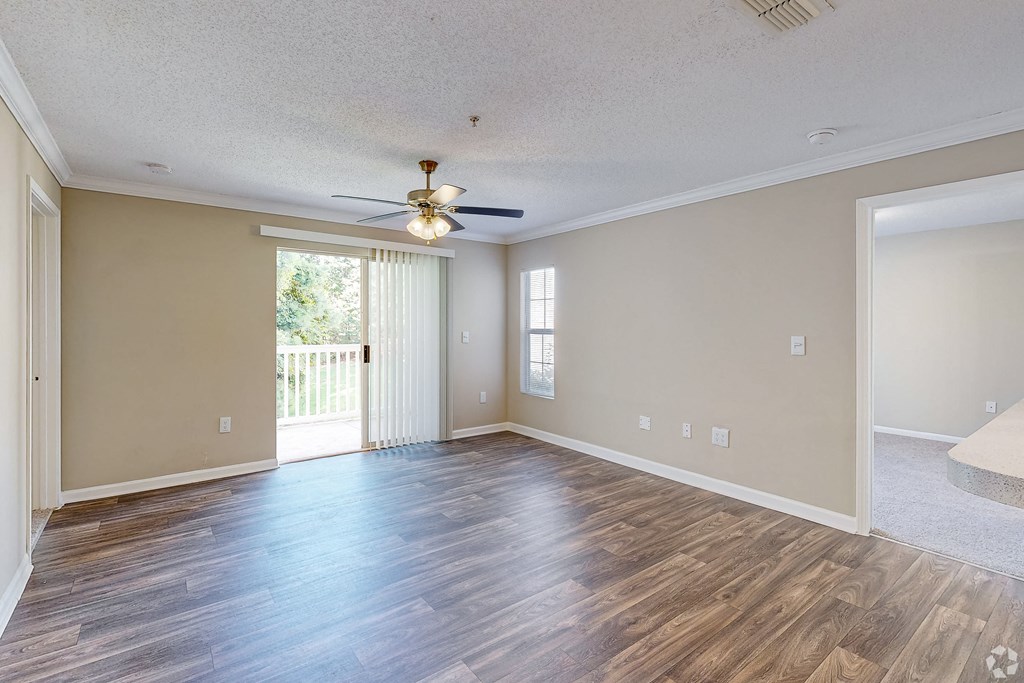 an empty living room with wood floors and a ceiling fan at Alexander Ridge Apartments, Canton , 30114