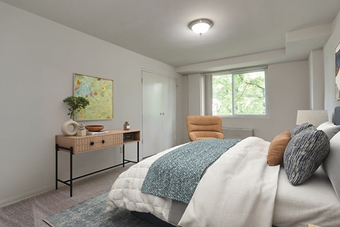 A bedroom with a bed, desk, and chair.