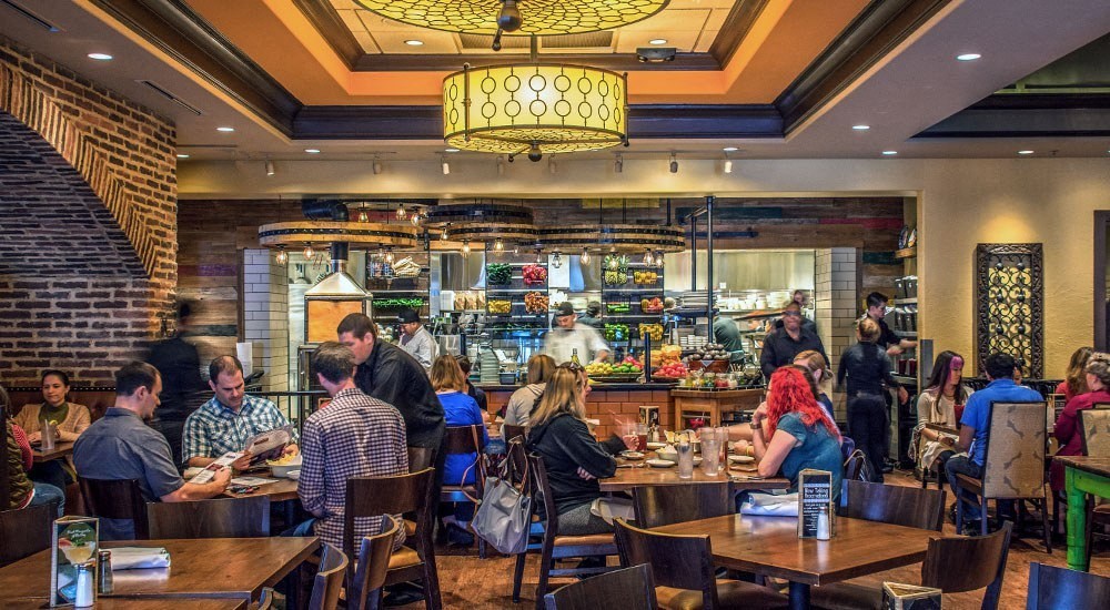a group of people sitting at tables in a restaurant at Vyne One Loudoun, Virginia