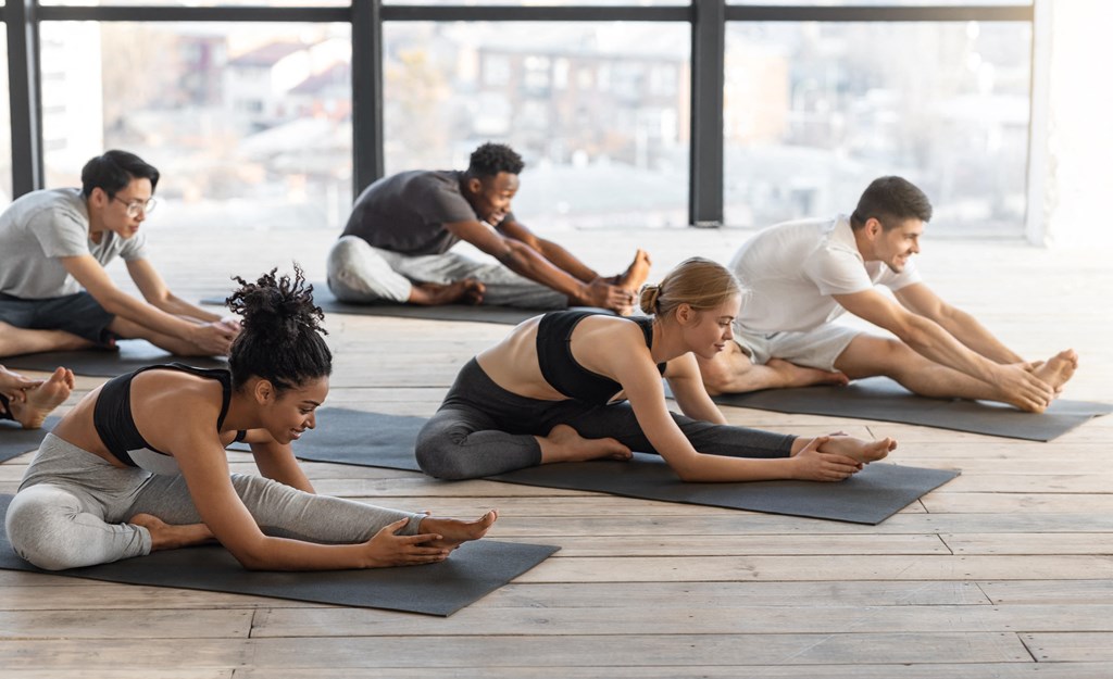a group of people doing yoga in a studio