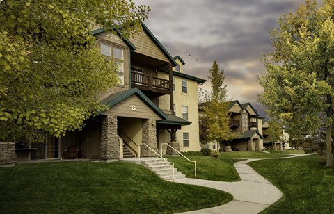 A large house with a green roof and a balcony.