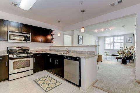 A modern kitchen with black cabinets and a white island.
