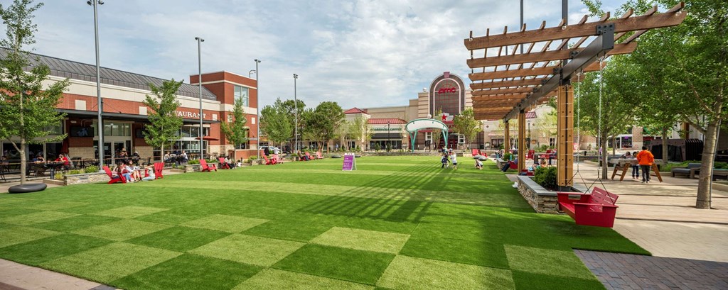 a park with a green lawn and a building in the background