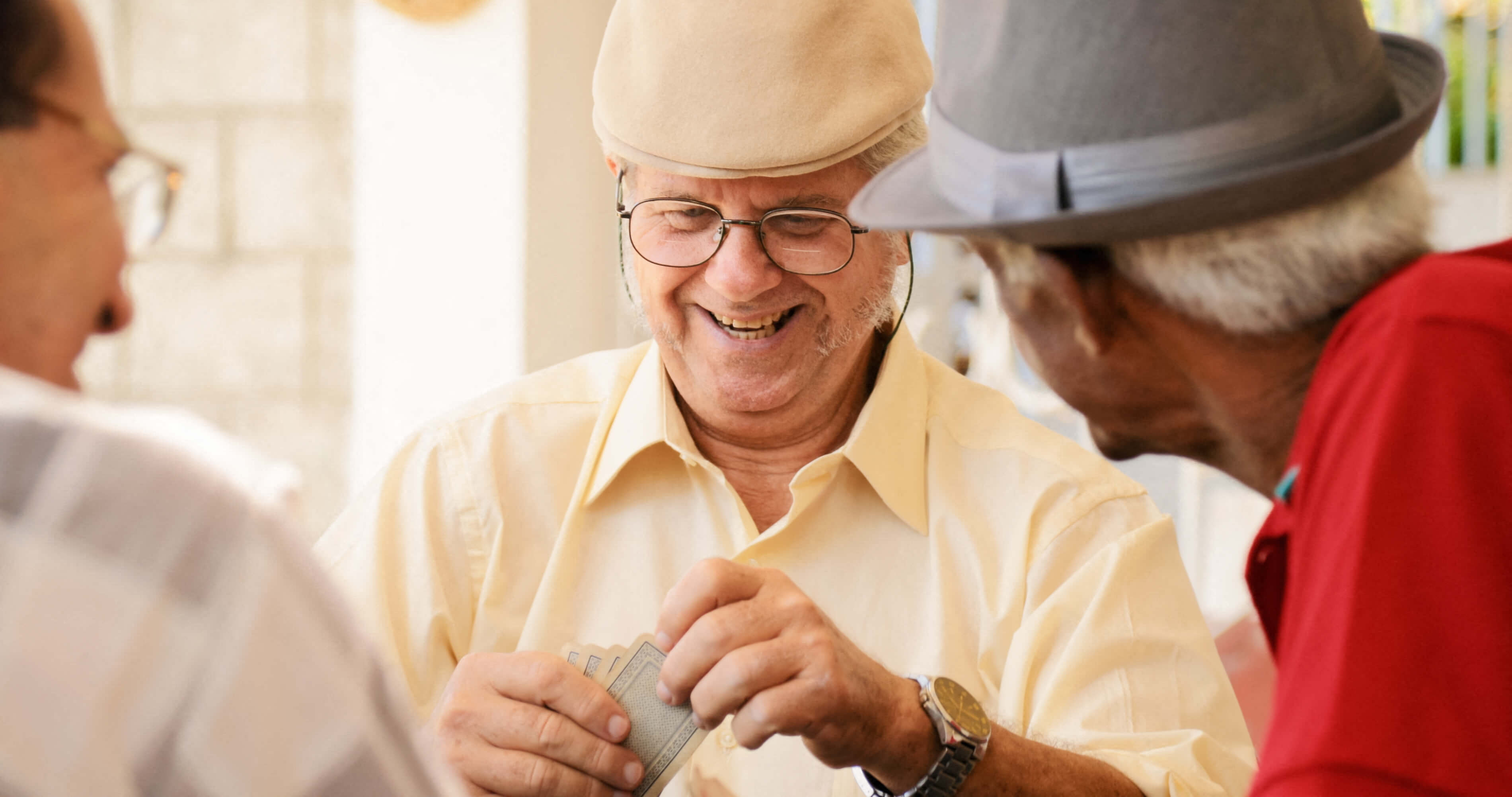 a group of men wearing hats laughing and playing cards