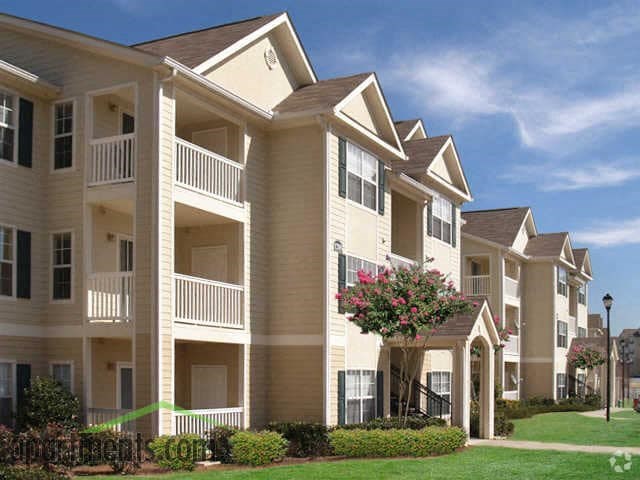 an apartment building with a flowering tree in front of it at Alexander Ridge Apartments, Canton , 30114
