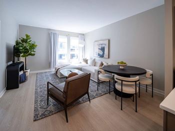 A living room with a black table and white chairs at Jayde Parkside Apartments, Washington 20019