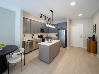 A modern kitchen with stainless steel appliances and a wooden island at Jayde Parkside Apartments, Washington, DC