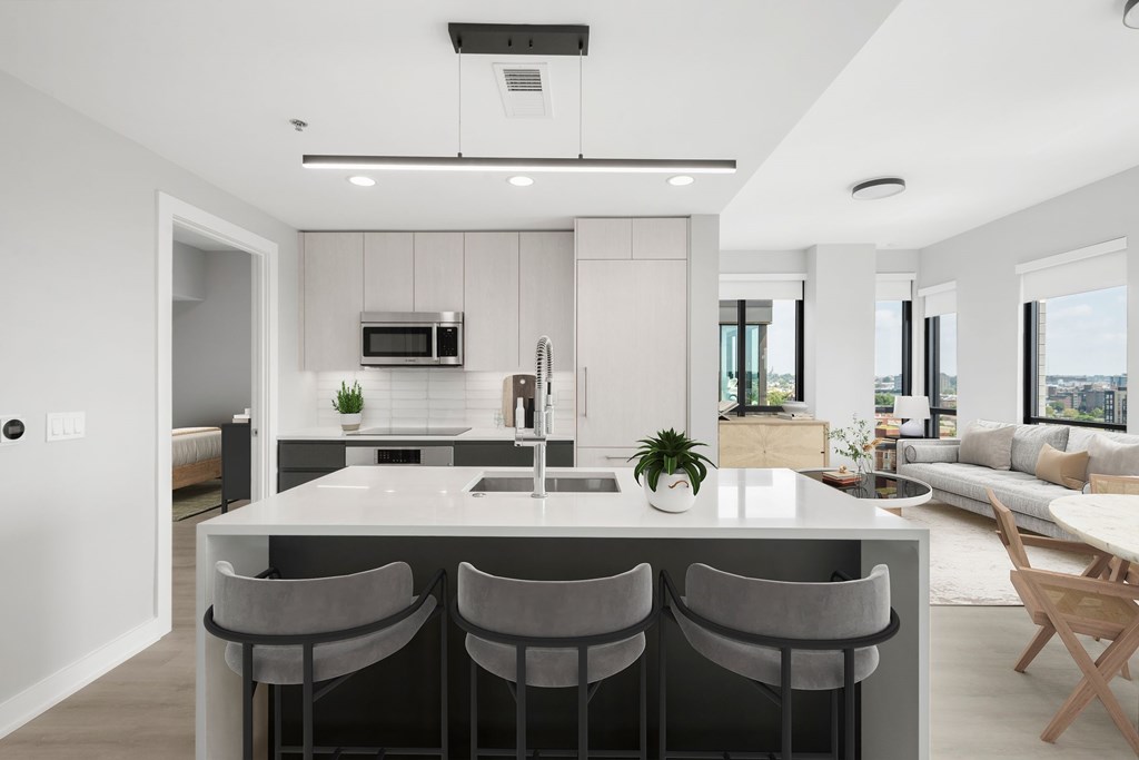 A modern kitchen with a bar area and a view of the outdoors.