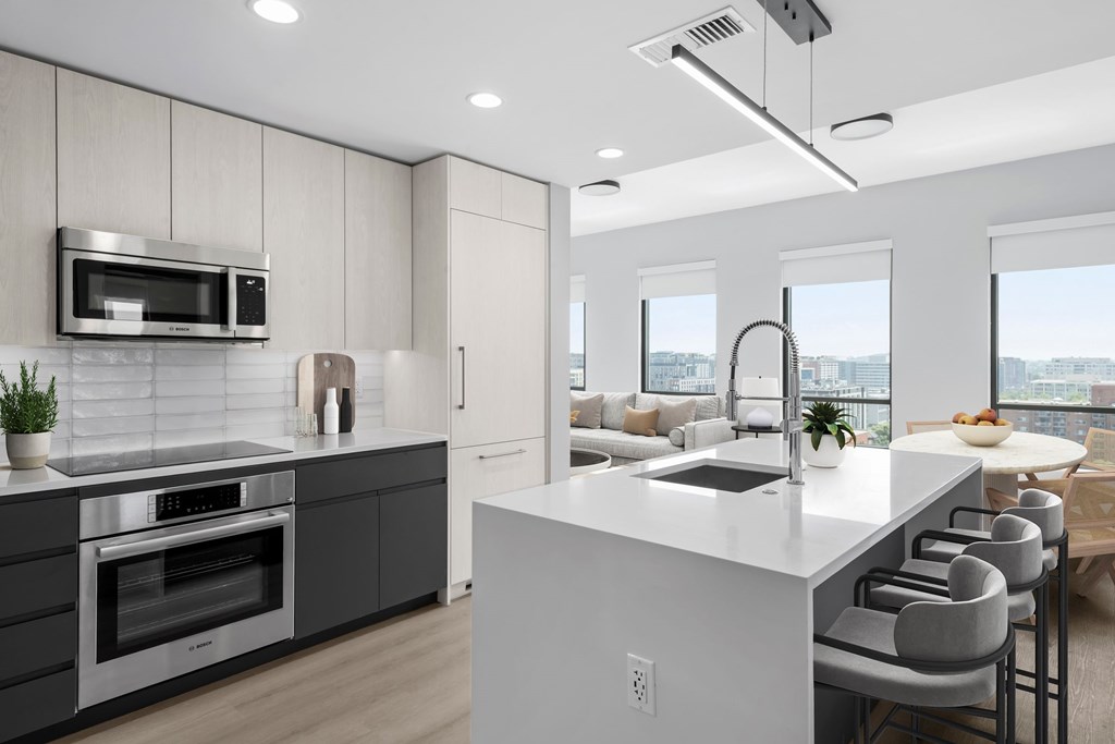 A modern kitchen with a large island and a view of the city.