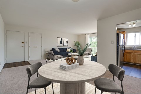 A modern dining room with a round table and grey chairs.