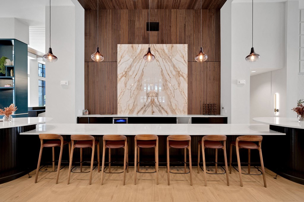 a large kitchen with a marble counter top and chairs at Preston Ridge, Cary