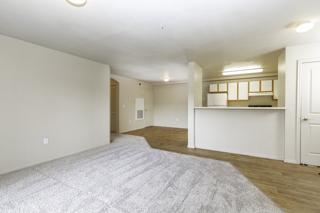 A spacious room with a grey carpet and white walls.at Sunset Ridge, West Jordan Utah