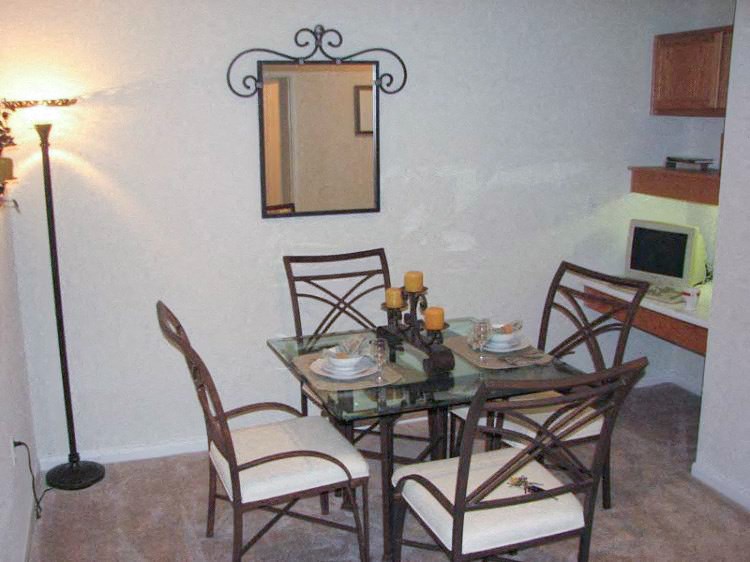 a dining room table with four chairs and a mirror