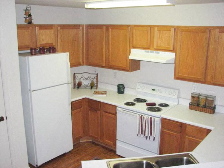 a kitchen with white appliances and wooden cabinets