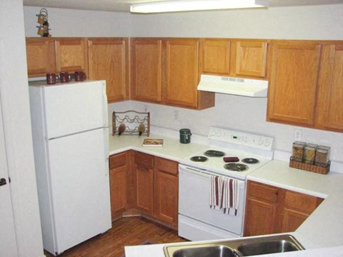 a kitchen with white appliances and wooden cabinets