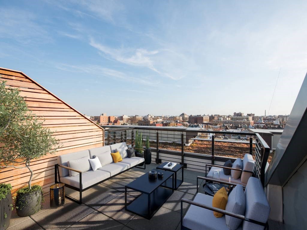 a terrace with couches and a table on a roof top