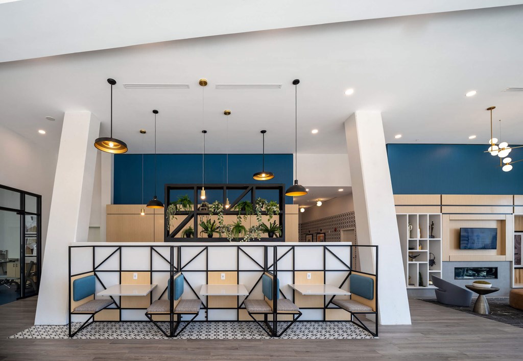 A modern waiting area with a blue accent wall and hanging plants at Jayde Parkside Apartments, Washington, DC, 20019