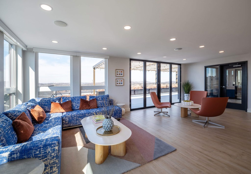 A living room with a blue couch and a white coffee table. at Jayde Parkside Apartments, Washington, Washington DC