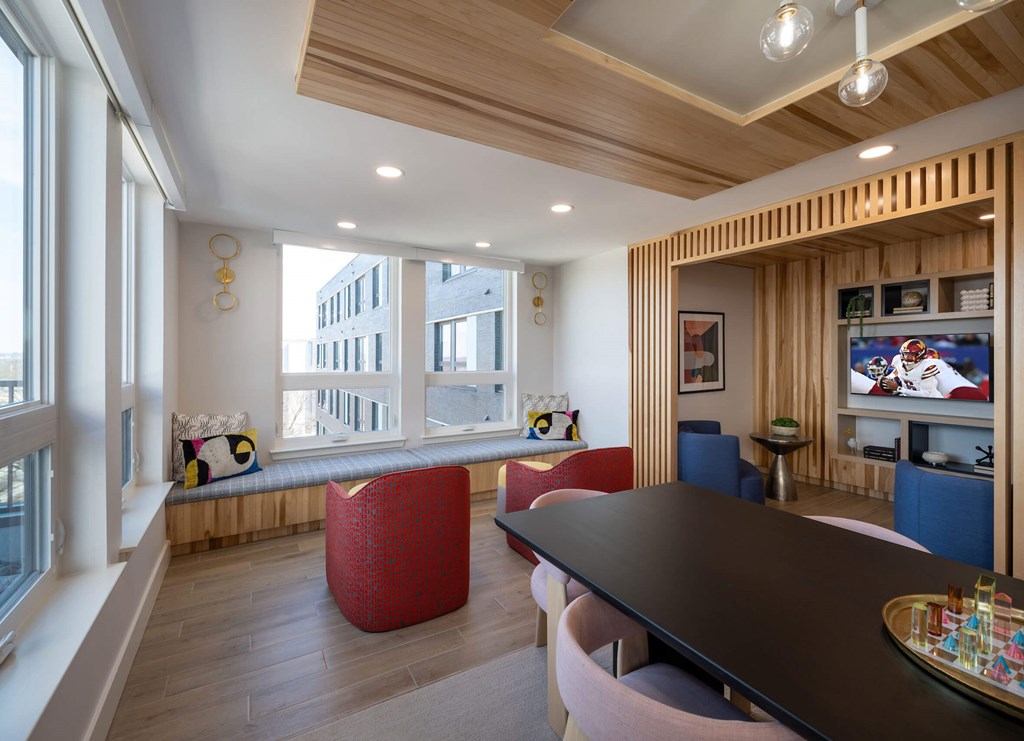 A modern living room with a large window, a TV, and a wooden ceiling. at Jayde Parkside Apartments, Washington