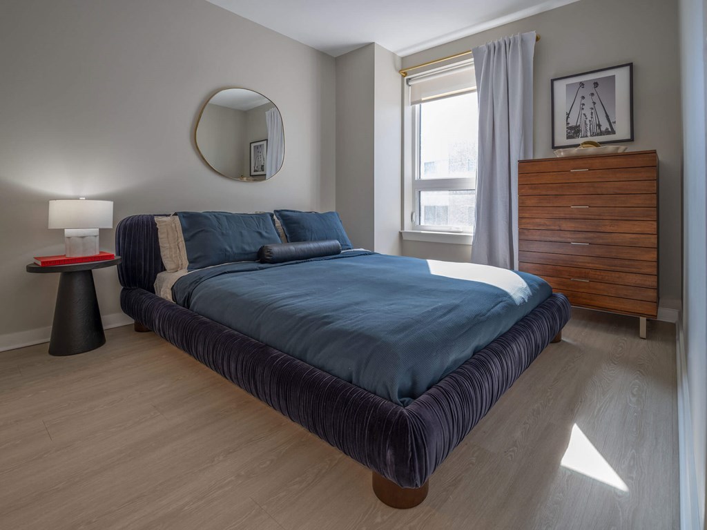 A bedroom with a large bed and a wooden headboard at Jayde Parkside Apartments, Washington DC