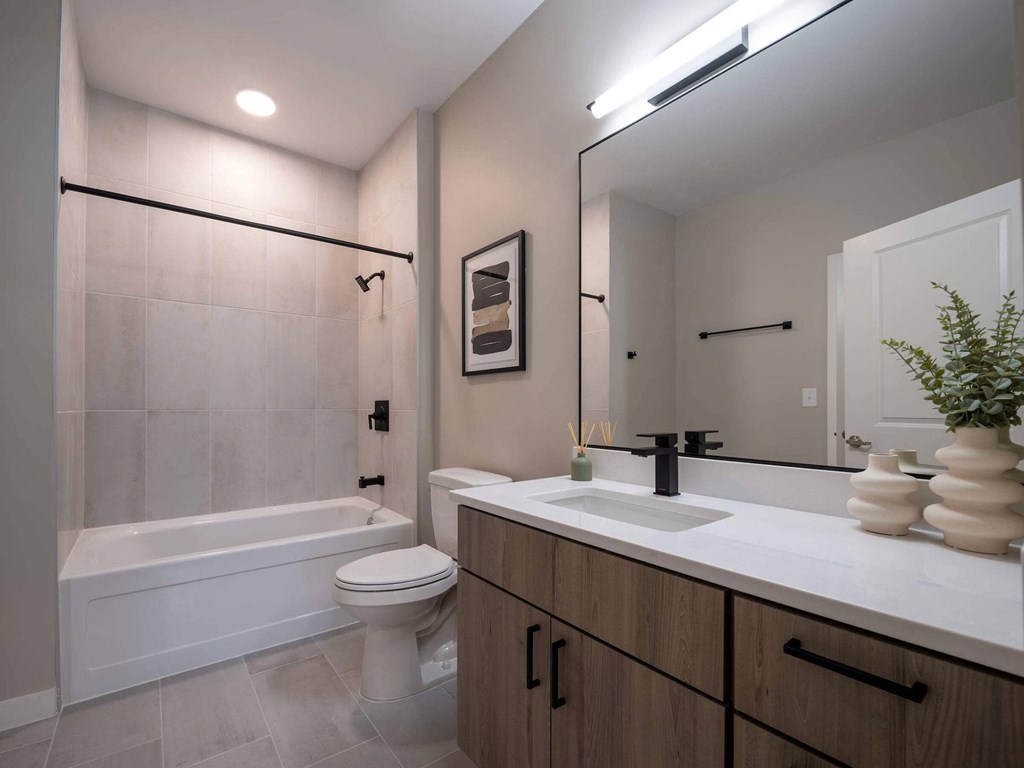 A modern bathroom with a white tub, sink, and toilet at Jayde Parkside Apartments, Washington 20019