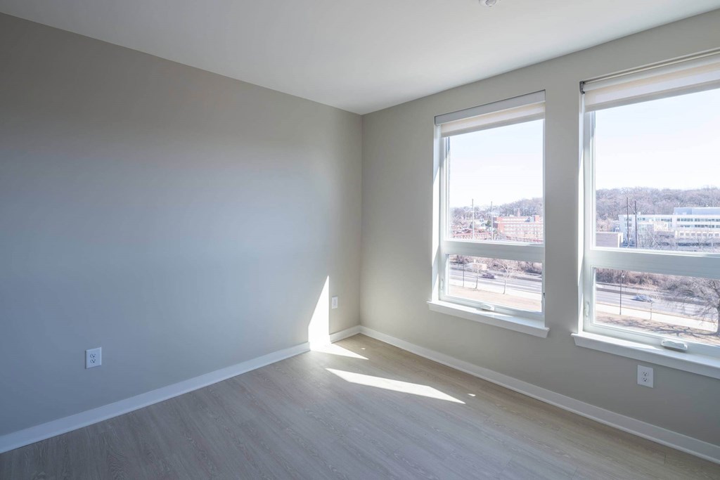 A room with a large window and a view of a parking lot outside at Jayde Parkside Apartments, Washington