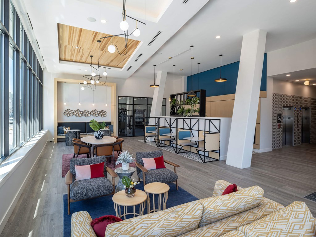 A modern living room with a large couch and a dining table at Jayde Parkside Apartments, Washington DC