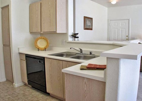 A kitchen with a white counter top and a black oven.