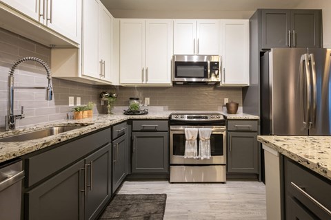 A modern kitchen with a stainless steel refrigerator and oven.
