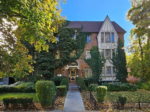 A large house with a gated entrance and a pathway leading to it.