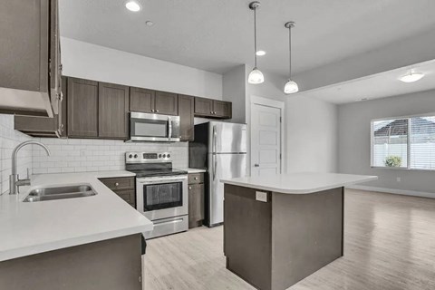 A modern kitchen with stainless steel appliances and a large island.