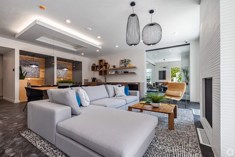 A modern living room with a grey sofa and a wooden coffee table.