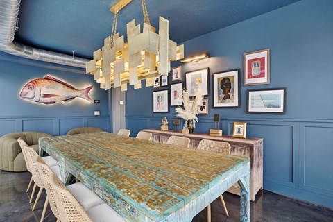 A dining room with a long table and chairs.