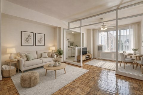 A living room with a white couch, a coffee table, and a dining table.