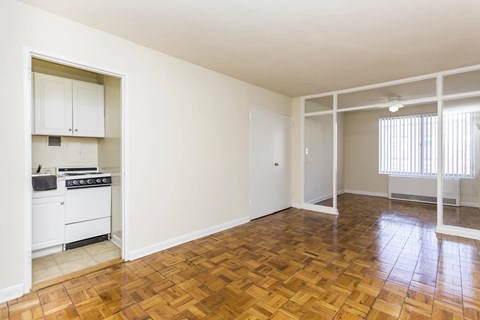 A kitchen with a stove top oven and a wooden floor.