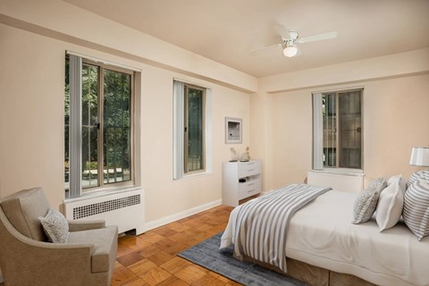 Bright bedroom with hardwood flooring and ceiling fan at Empire Apartments, Washington