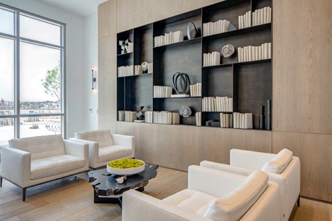 A modern living room with white furniture and a black coffee table.