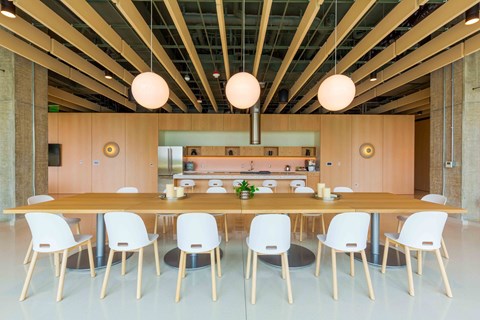 Modern communal kitchen with dining table and pendant lights at Allied Harbor Point Apartments, Baltimore, MD 21231