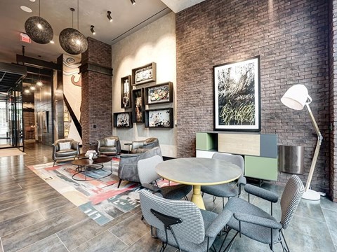 A room with a brick wall and a table with chairs.