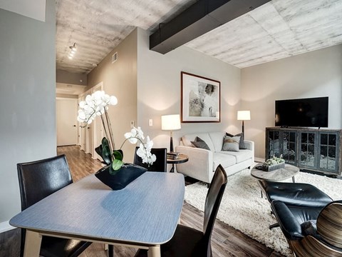 A modern dining room with a wooden table and chairs.