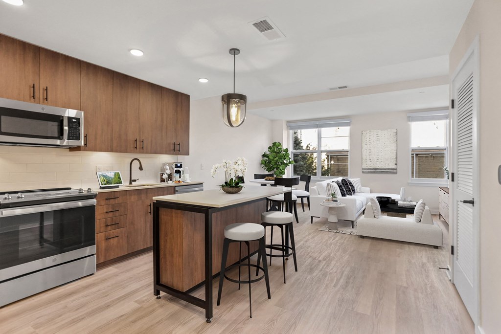 an open kitchen and living room with a large island with stools