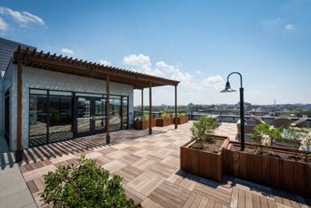 a roof terrace with wooden planters and a building