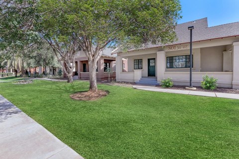 A tree in front of a building with the number 101 on it at Roosevelt Commons Apartments, Phoenix, AZ, 85003