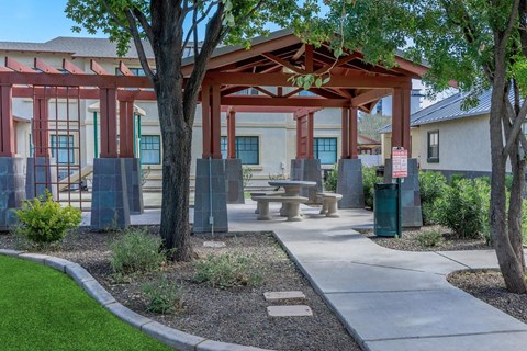 A covered outdoor seating area with a table and chairs at Roosevelt Commons Apartments, Phoenix, 85003