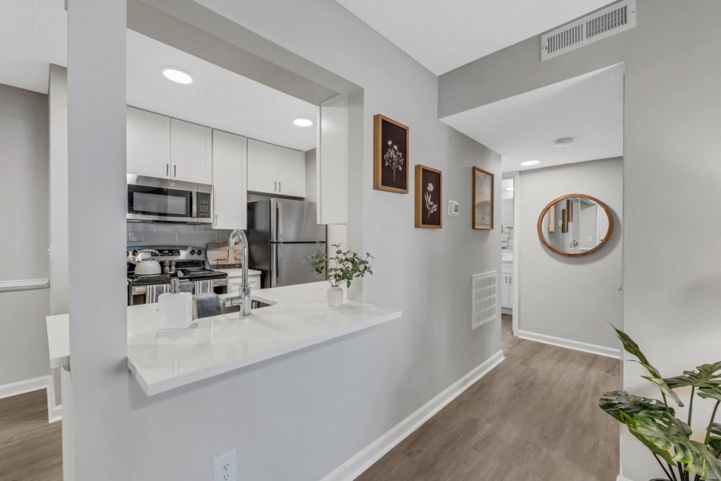 a kitchen with white cabinetry and a white counter top with a vase of flowers on  at Brampton Moors, North Carolina, 27513