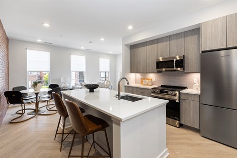 A modern kitchen with a white island and stainless steel appliances.