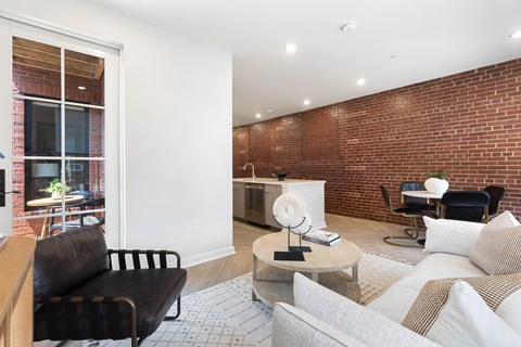 A living room with a black leather chair and a white couch.