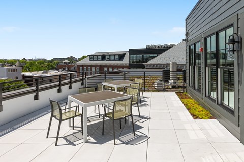 A patio with a table and chairs is surrounded by buildings.