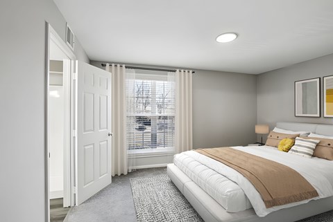 A bedroom with a large bed and a window with blinds at The Overlook at Quantico Apartments, Triangle, VA, 22172