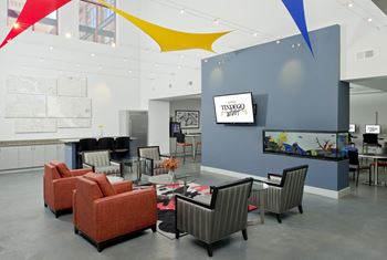 a large lobby with chairs and tables and a tv at Tindeco Wharf, Baltimore, MD